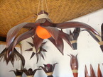 Un chandelier en bamboo et avec un boule en papier fait artisanalement